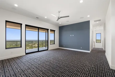 a view of an empty room with a window and a ceiling fan