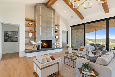 a living room with furniture fireplace and a large window
