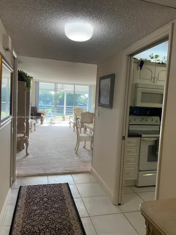 a kitchen with granite countertop a refrigerator and a stove top oven