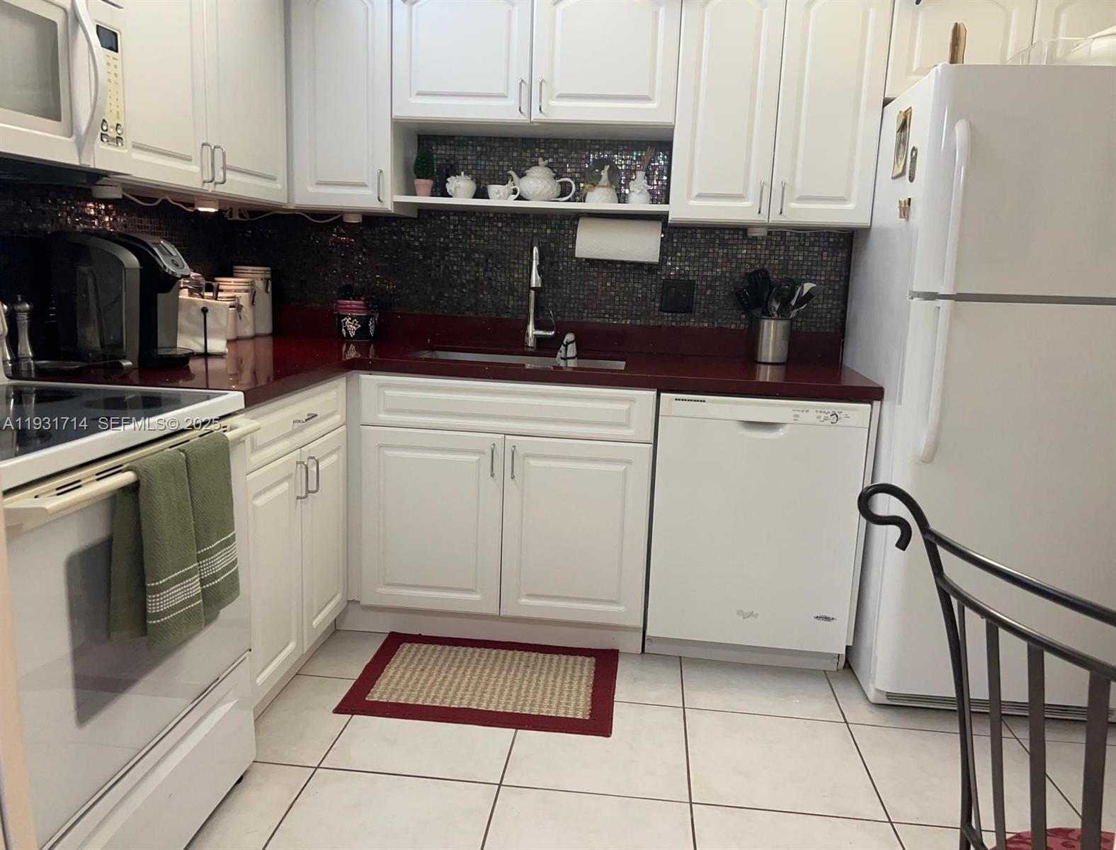 821 Cypress Boulevard, Unit 312 Pompano Beach, FL 33069 - Photo 15 of 52 a kitchen with a refrigerator and cabinets