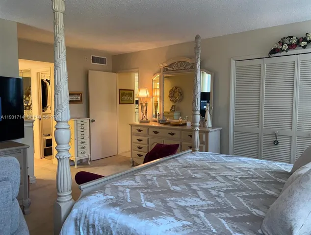 a bedroom with a bed and a large mirror