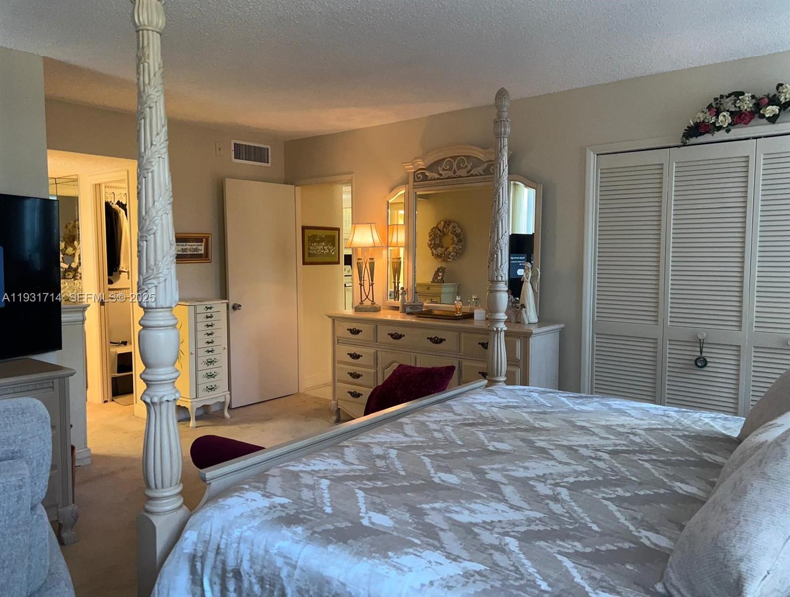 821 Cypress Boulevard, Unit 312 Pompano Beach, FL 33069 - Photo 29 of 52 a bedroom with a bed and a large mirror