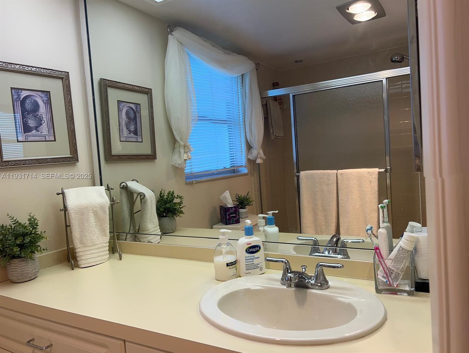 821 Cypress Boulevard, Unit 312 Pompano Beach, FL 33069 - Photo 39 of 52 a bathroom with a sink and a mirror