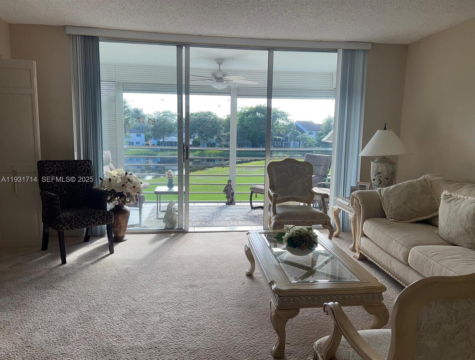 821 Cypress Boulevard, Unit 312 Pompano Beach, FL 33069 - Photo 6 of 52 a living room with furniture and a floor to ceiling window