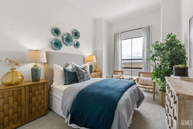 a bedroom with a bed dresser and a potted plant