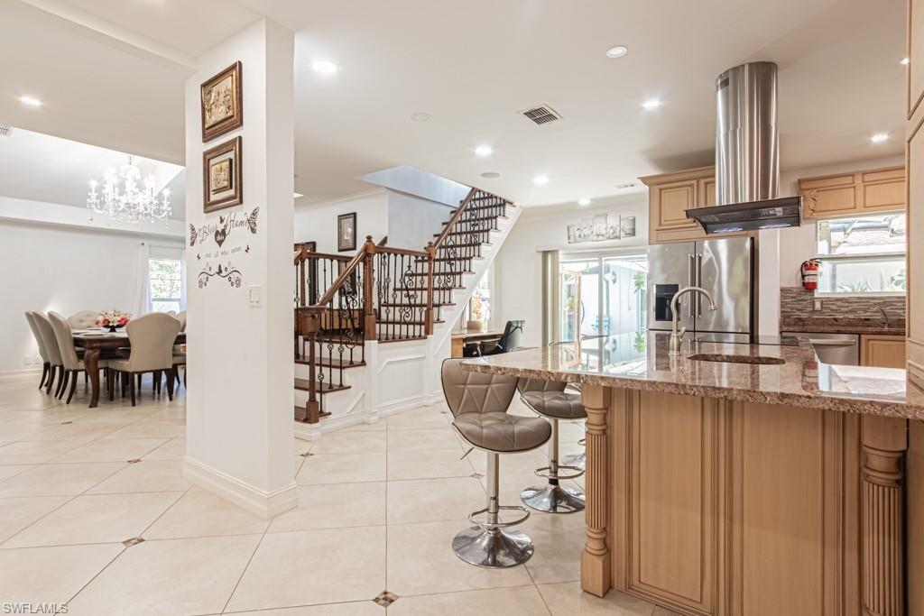740 31st Street Southwest Naples, FL 34117 - Photo 27 of 50 a kitchen with stainless steel appliances kitchen island granite countertop a table and chairs
