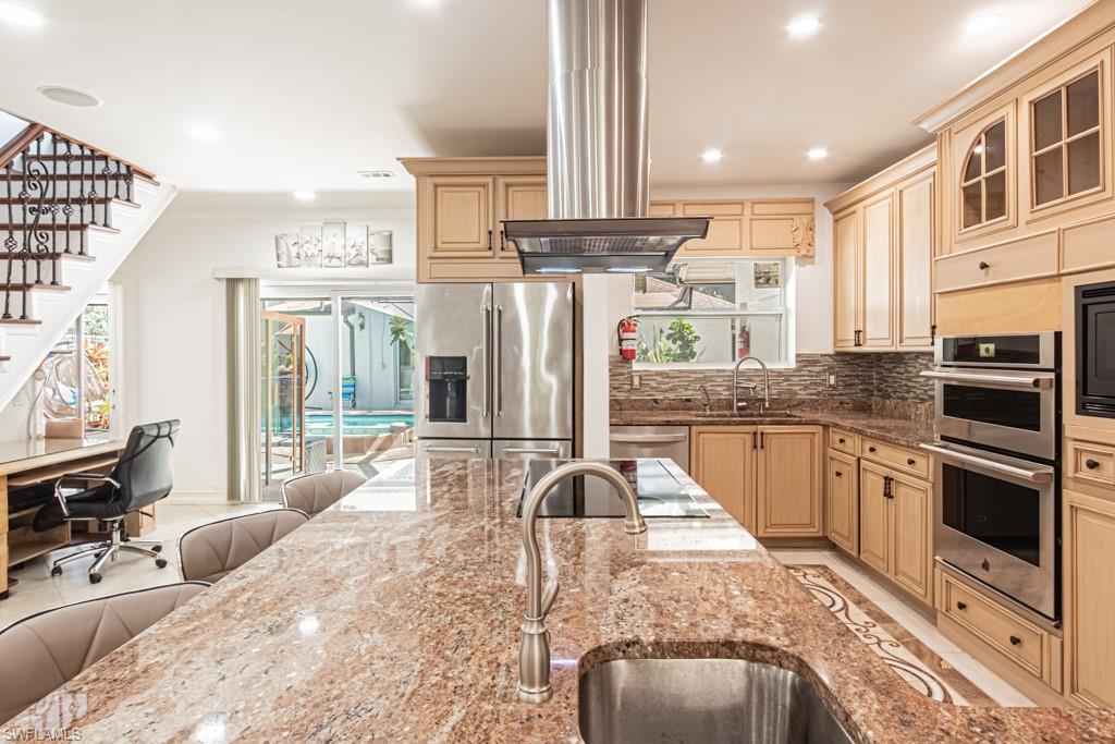 740 31st Street Southwest Naples, FL 34117 - Photo 28 of 50 a kitchen with stainless steel appliances granite countertop a stove a sink and a refrigerator