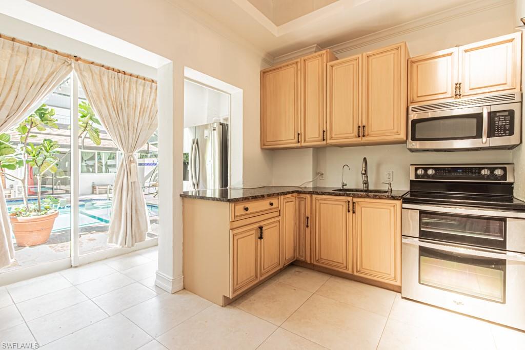 740 31st Street Southwest Naples, FL 34117 - Photo 45 of 50 a kitchen with stainless steel appliances granite countertop a refrigerator and cabinets