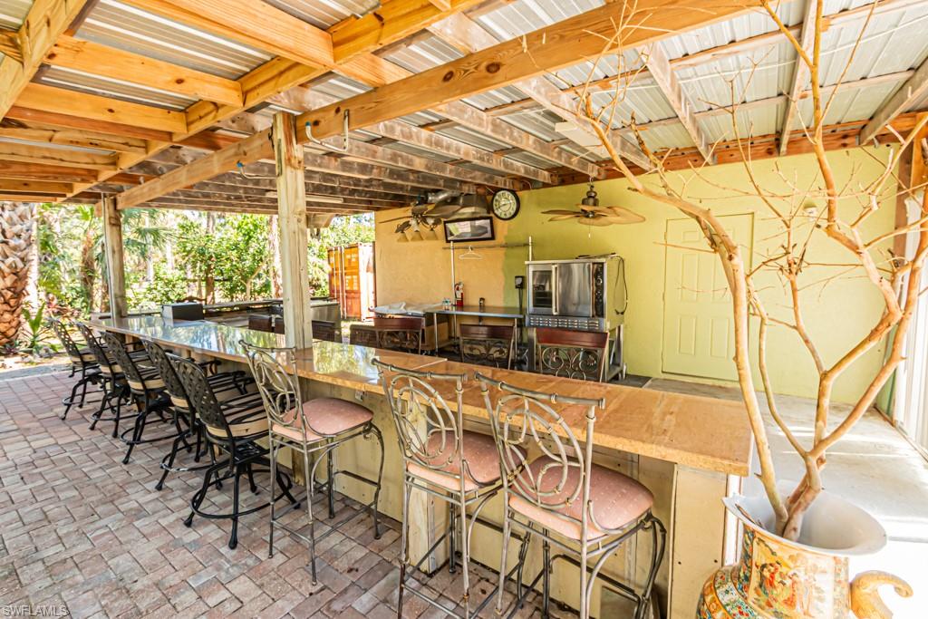 740 31st Street Southwest Naples, FL 34117 - Photo 10 of 50 a view of a patio with a table and chairs and potted plants