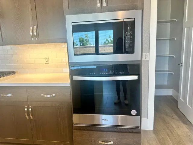 a large kitchen with stainless steel appliances a large counter top a stove and a sink