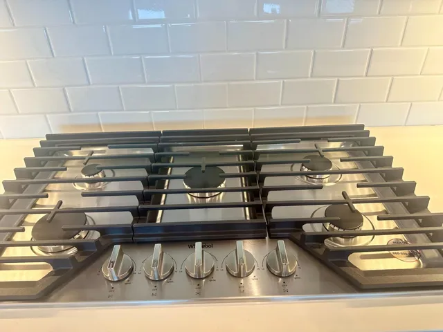 a view of kitchen with stainless steel appliances granite countertop a stove and a sink
