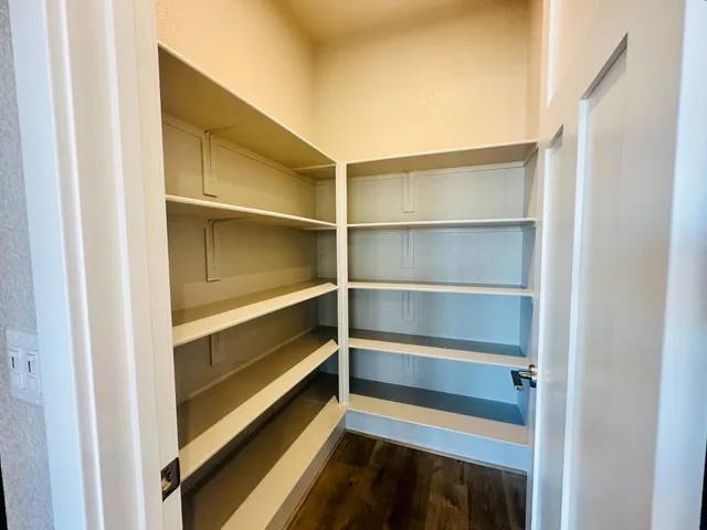 an empty room with windows and chandelier fan