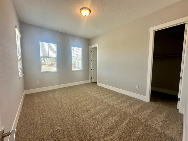an empty room with windows and closet