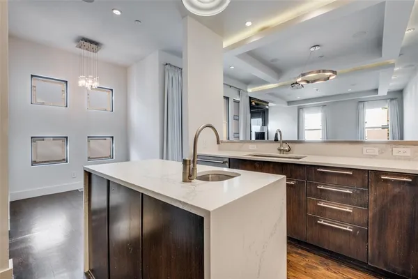 a kitchen with stainless steel appliances granite countertop a sink a stove and a wooden floors