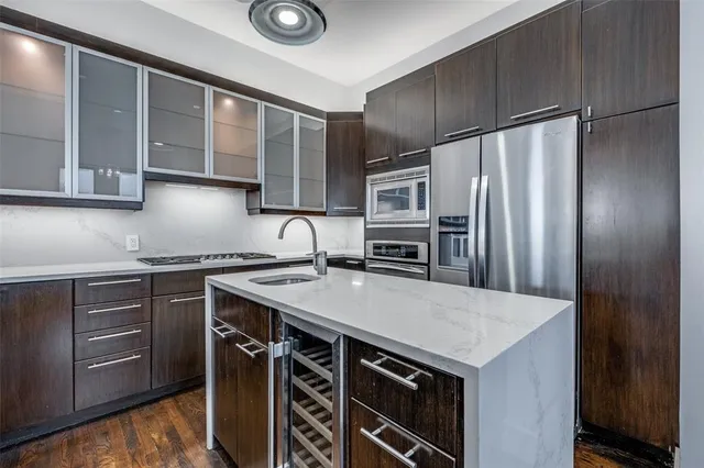 a kitchen that has a sink stainless steel appliances and cabinets