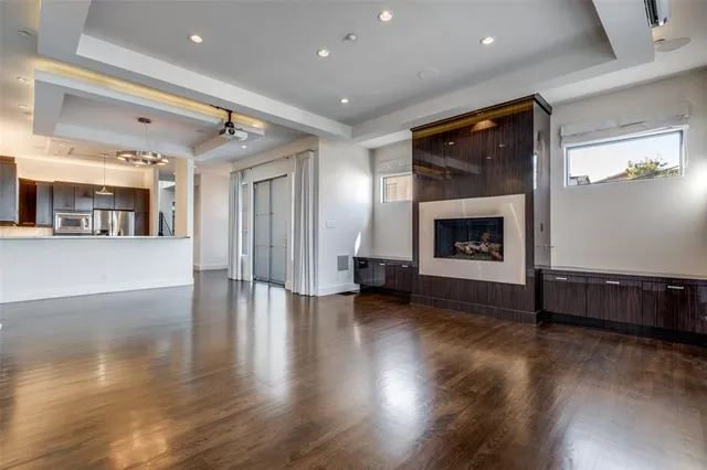 a view of a livingroom with wooden floor and a fireplace