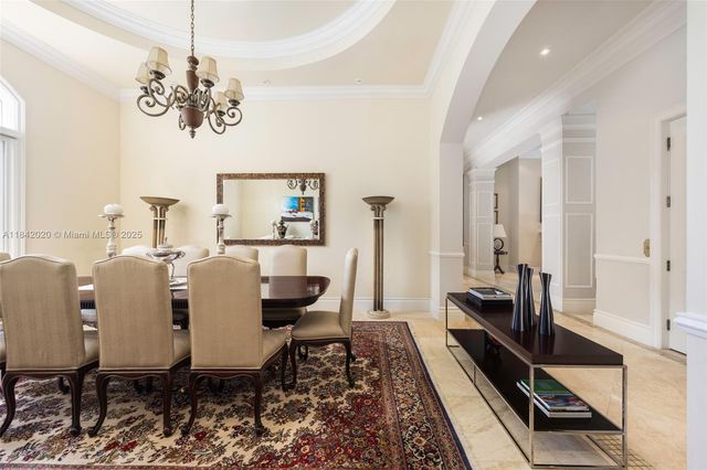 a view of a dining room with furniture a chandelier and wooden floor