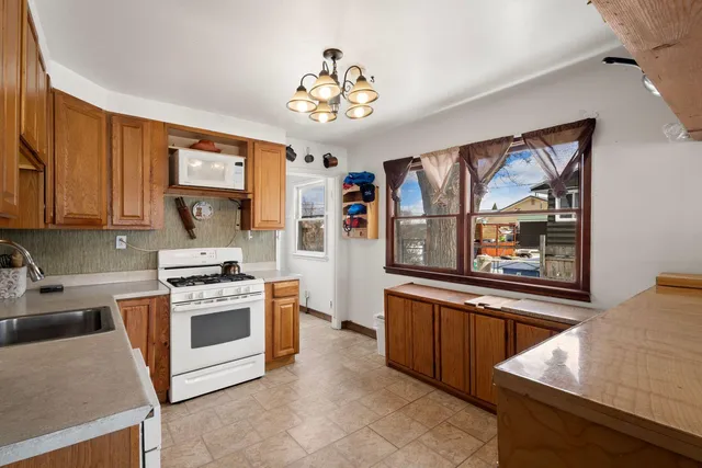a kitchen with stainless steel appliances granite countertop a stove top oven a sink a counter space and cabinets