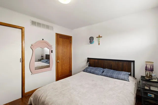 a bedroom with a bed and a dresser with the shoe rack