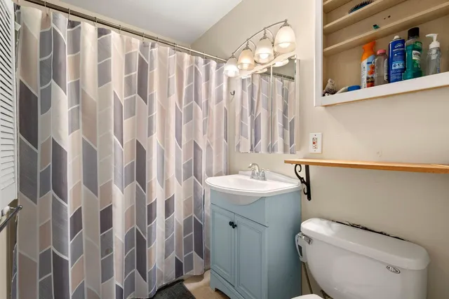 a bathroom with a toilet sink and shower curtain