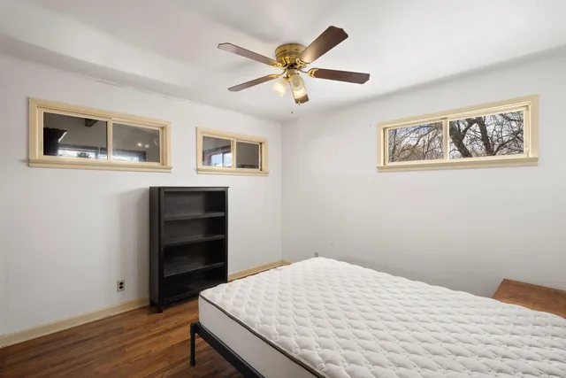 a bedroom with a bed and a ceiling fan