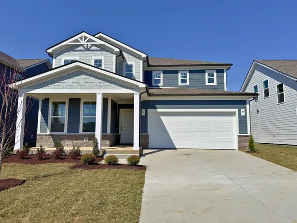 a front view of a house with yard and parking