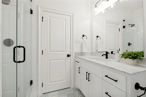 a bathroom with a tub sink vanity and mirror