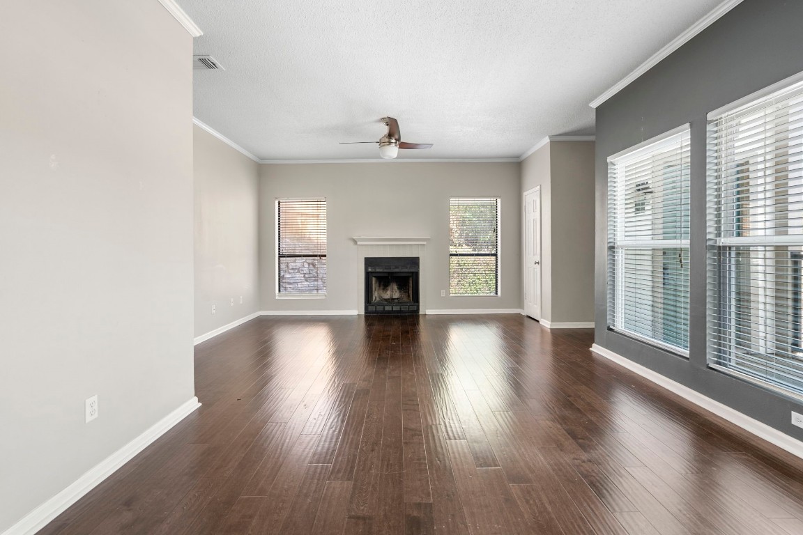 6600 Valleyside Road, Unit E32 Austin, TX 78731 - Photo 1 of 1 an empty room with wooden floor fireplace and windows