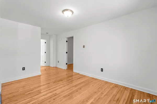 a view of an empty room with wooden floor