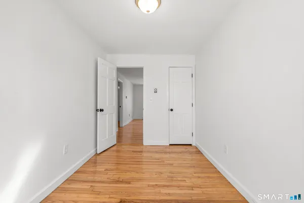 a view of an empty room with wooden floor