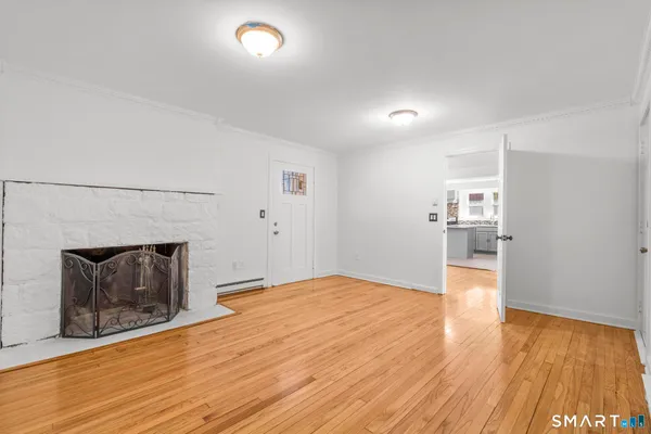 a view of empty room with wooden floor and fireplace