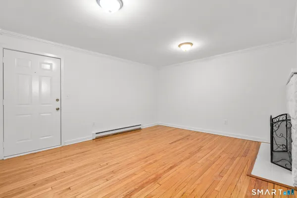 a view of empty room with wooden floor