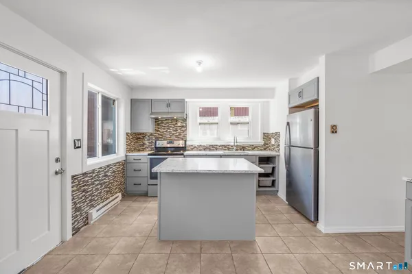 a kitchen with stainless steel appliances a refrigerator sink and cabinets