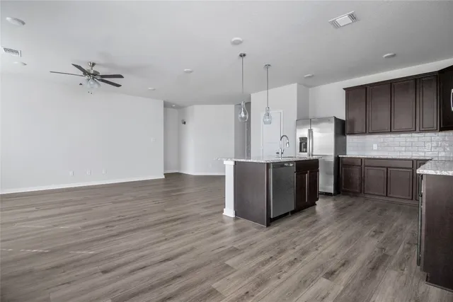 a kitchen with stainless steel appliances a sink cabinets and wooden floor