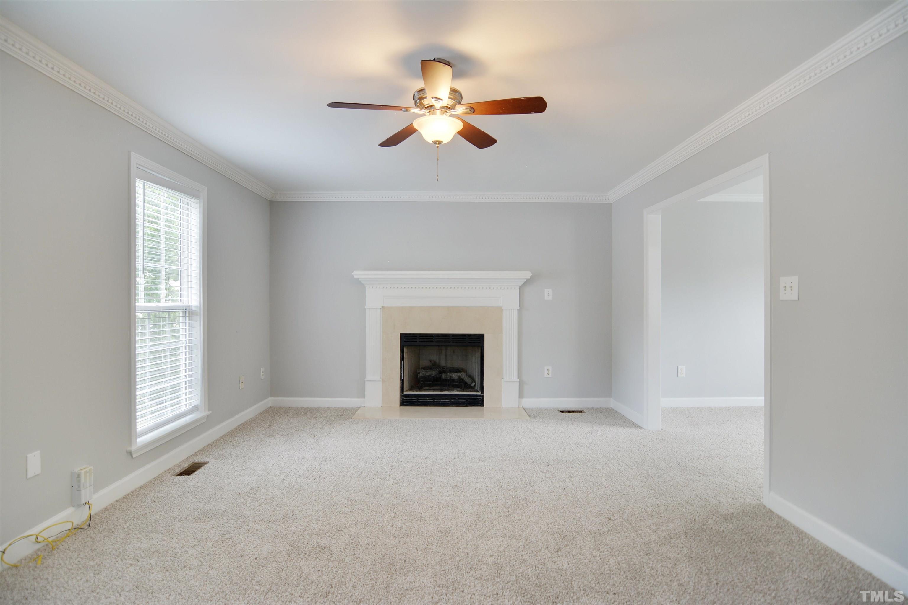 9221 Pennythorne Court Raleigh, NC 27615 - Photo 2 of 23 an empty room with windows and fireplace