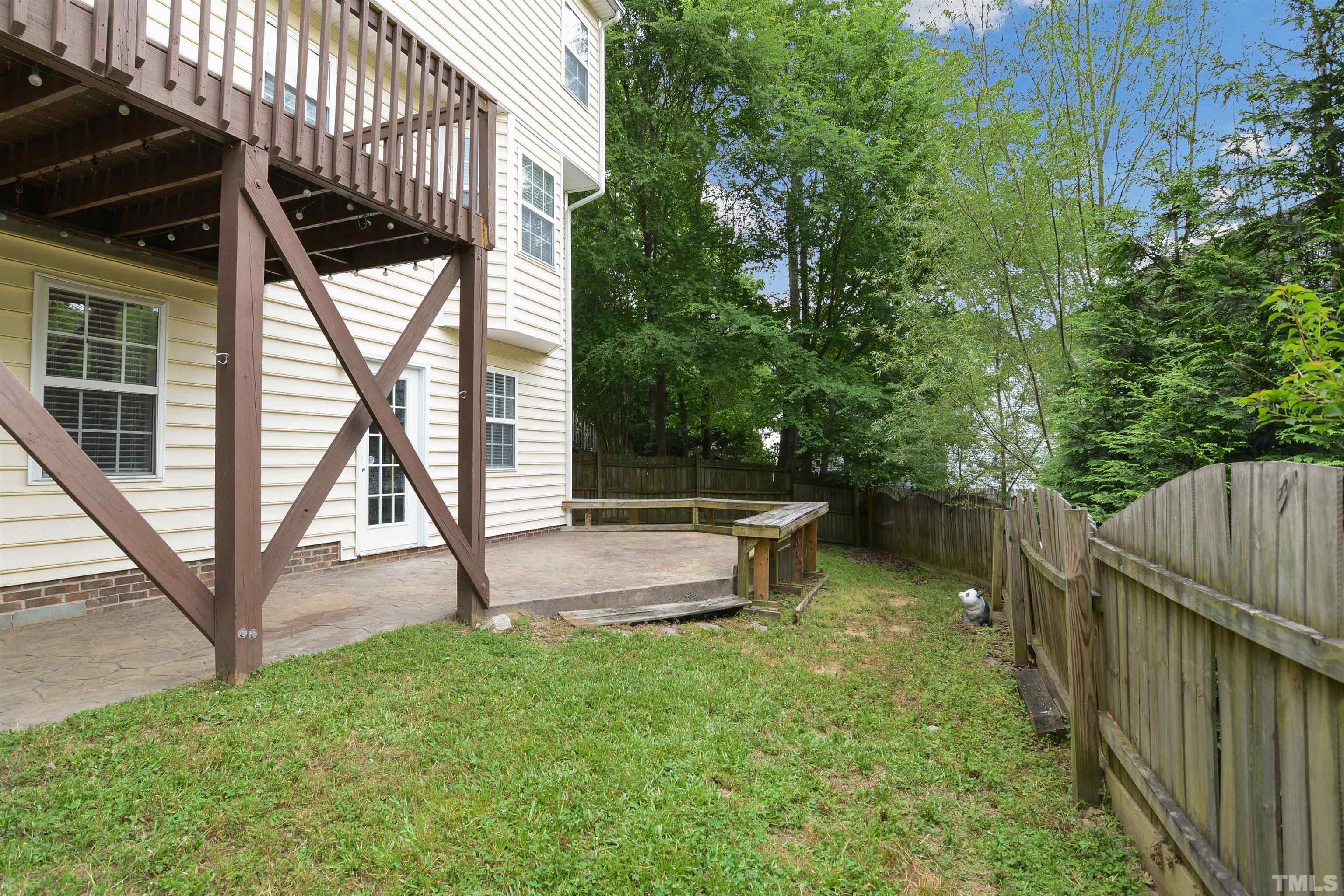9221 Pennythorne Court Raleigh, NC 27615 - Photo 23 of 23 a view of a backyard with wooden fence and a bench