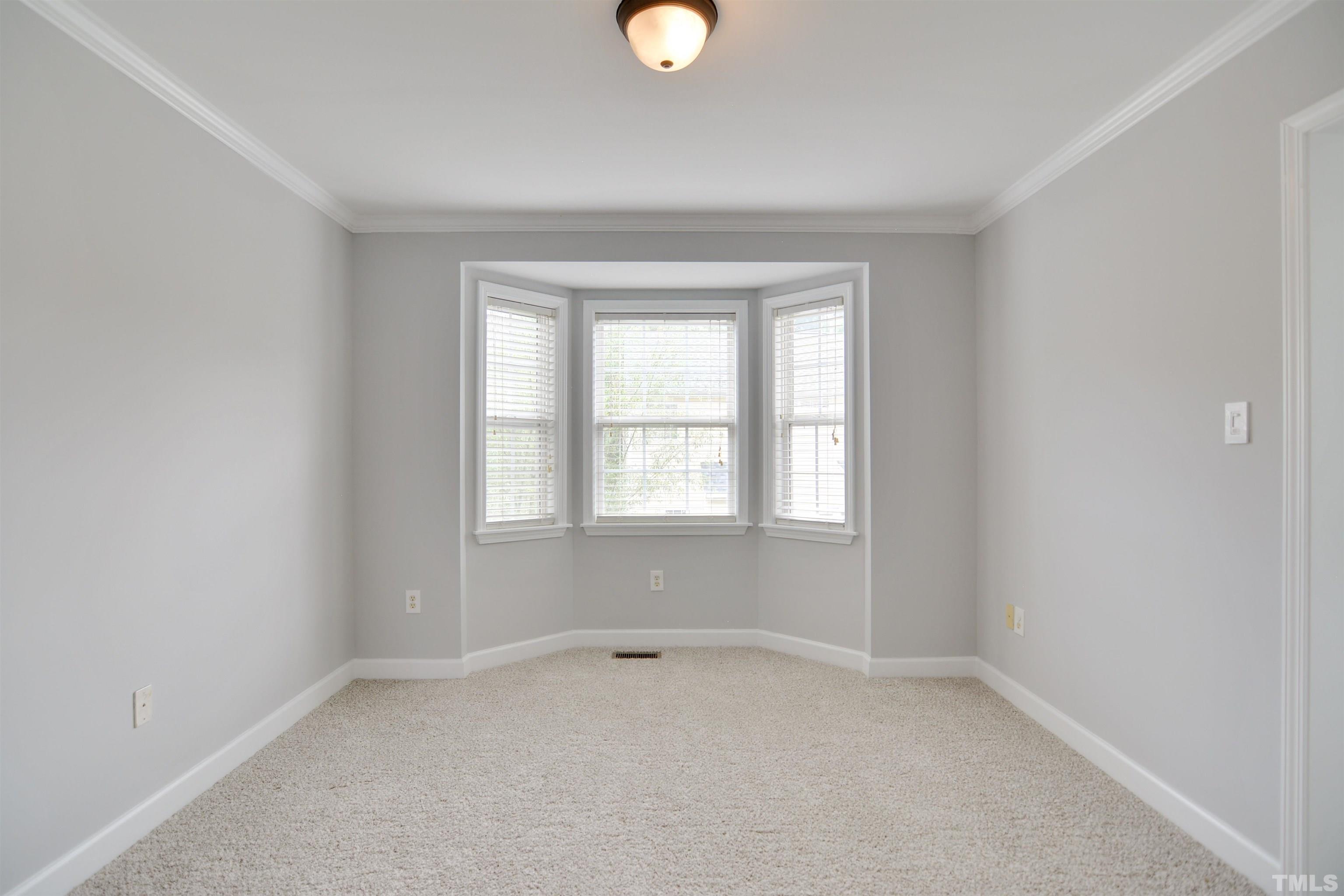 9221 Pennythorne Court Raleigh, NC 27615 - Photo 4 of 23 an empty room with a window and a lamp