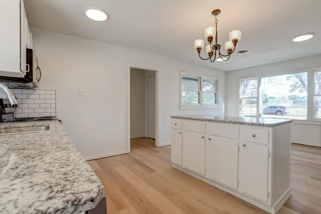 a kitchen with granite countertop cabinets a sink and dishwasher a granite countertops with wooden floor