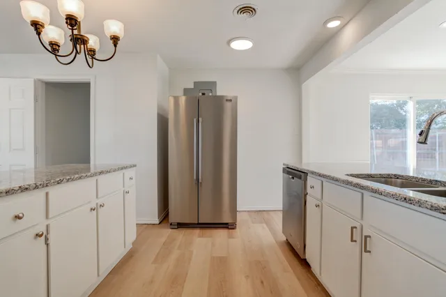 a kitchen with stainless steel appliances granite countertop a stove a microwave and a refrigerator