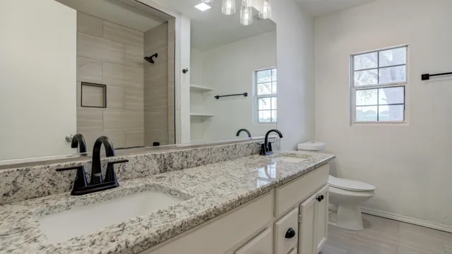 an empty room with wooden floor ceiling fan and windows