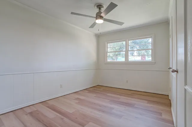 a view of an empty room with wooden floor