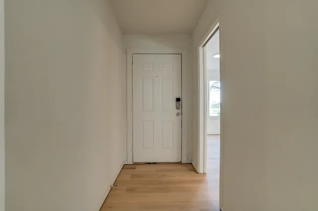 a view of a kitchen with refrigerator and wooden floor