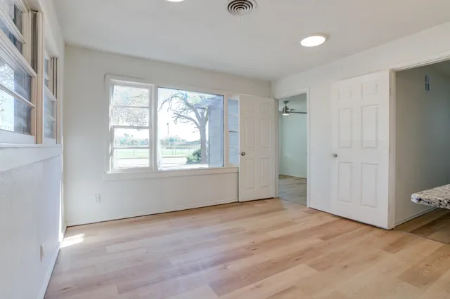 a view of kitchen with granite countertop cabinets and refrigerator