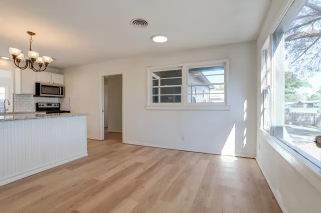 a kitchen with white cabinets and appliances