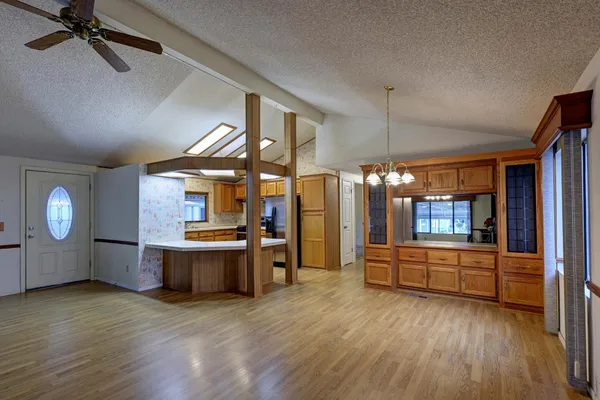 a view of a living room and kitchen with furniture wooden floor and window