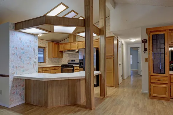 a kitchen with stainless steel appliances granite countertop a refrigerator a sink and a stove