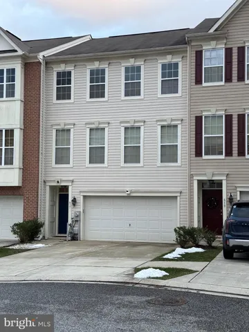 a front view of a house with yard and parking space