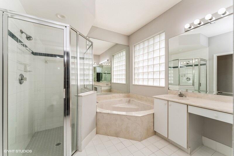 6427 Wild Olive Lane Stuart, FL 34997 - Photo 9 of 11 a bathroom with a tub sink shower and mirror