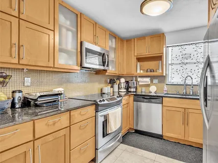 a kitchen with stainless steel appliances granite countertop a sink a stove a microwave and cabinets