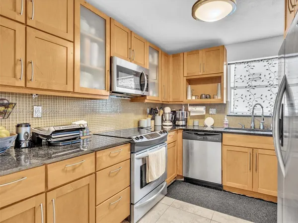 a kitchen with stainless steel appliances granite countertop a sink a stove a microwave and cabinets